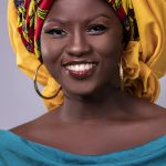 Captivating studio portrait of a smiling woman wearing a colorful headscarf.