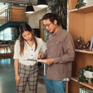 Two colleagues engage in a collaborative discussion in a stylish, modern office environment.
